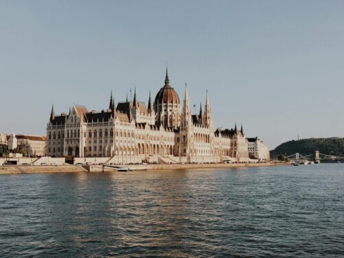 white and brown building beside body of water
